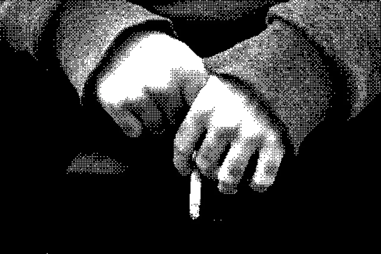 Manos sosteniendo un cigarrillo, en blanco y negro.